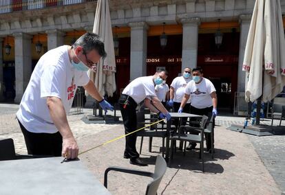 Varios trabajadores preparan una terraza en la Plaza Mayor de Madrid para su reapertura este lunes. La Comunidad de Madrid entra en la fase 1 de la desescalada, lo que supone flexibilizar buena parte de las restricciones impuestas por el estado de alarma, aunque algunas se habían levantado ya en la fase 0,5 del desconfinamiento.