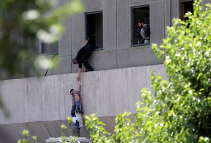 Un niño es evacuado por la fachada del parlamento iraní durante un ataque en Teherán, el 7 de junio de 2017.