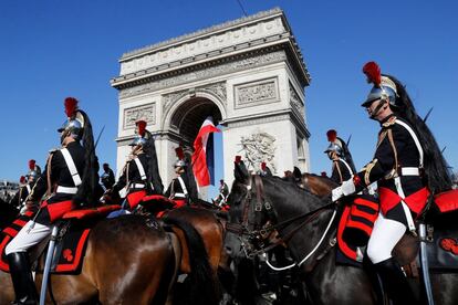 Guardias republicanos franceses a caballo pasan cerca del Arco del Triunfo de París.