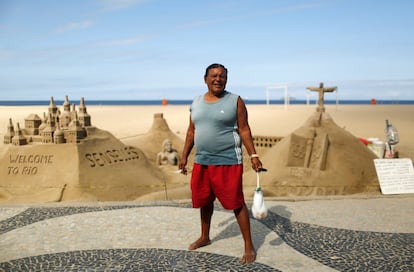 Xavier Fonseca, escultor de areia de 70 anos, posa para a foto na praia de Copacabana, no Rio de Janeiro. Ao ser perguntado por sua opinião sobre os Jogos Olímpicos, Xavier responde: “É uma grande oportunidade para as pessoas que trabalham com o turismo”. Também pensa que os cariocas se beneficiarão das melhorias no transporte público realizadas antes do evento.