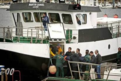 La Guardia Civil traslada a tierra uno de los cadáveres de los dos marineros fallecidos tras hundirse su pesquero