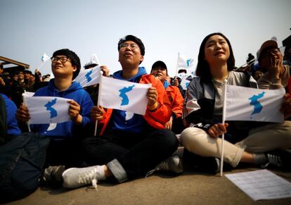 Vecinos de la localidad de Paju, en Corea del Sur, levantan banderas de la unificación coreana.