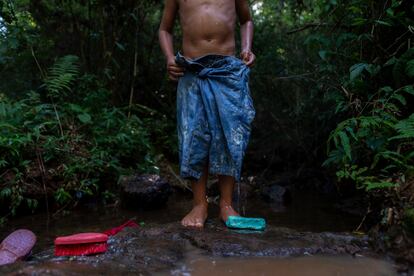 Daniel limpia su ropa en una laguna de la selva misionera durante un día de verano de 2014. La cosecha de la yerba mate no es la única de la región: en la selva también se cultivan árboles de pino, que amenazan los suministros de agua en la zona. La Laguna Escondida en la que los niños de Cuatro Bocas pasan sus tardes de verano suele desaparecer cuando el cultivo del pino está en auge. 
