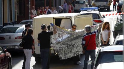 Trabajadores de una funeraria trasladan el cadáver de la mujer, ayer en el barrio bilbaíno de Deusto. 