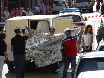 Trabajadores de una funeraria trasladan el cadáver de la mujer, ayer en el barrio bilbaíno de Deusto. 