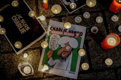 Un semanario de Charlie Hebdo rodeado de velas en la acera junto a la embajada de Francia en Berln, tras el atentado en la redaccin del semanario parisino en enero de 2015.