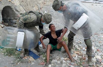 Un chico marroquí es auxiliado por el ejército español al llegar a El Tarajal, en mayo.