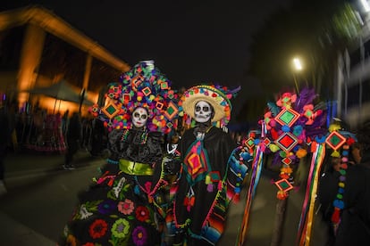 Los orígenes de la celebración del Día de Muertos en México son anteriores a la llegada de los españoles. Hay constancia de celebraciones en las etnias mexica, maya purépecha y totonaca, y entre los pueblos prehispánicos era común la práctica de conservar los cráneos como trofeos y mostrarlos durante los rituales que simbolizaban la muerte y el renacimiento. En la imagen, una mujer y un hombre disfrazados de Catrina y Catrín recorren una calle de la ciudad de Toluca, el 1 de noviembre de 2023.