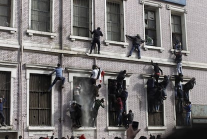 Manifestantes escalan por la fachada de un edificio cercano al ministerio del Interior.