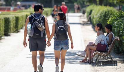 Dos jóvenes pasean esta mañana por un parque de Madrid. 