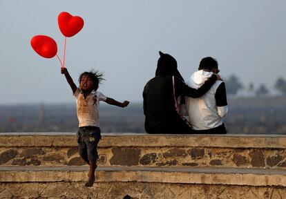 Un niño salta en el paseo de la costa de Bombay después de intentar vender globos en forma de corazón a una pareja por el día de San Valentín (India).