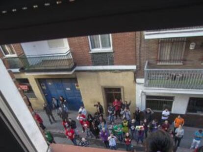 La hija de una familia que va a ser desahuciada mira por la ventana a un grupo de activistas que protestan contra el desalojo de la vivienda, el pasado d&iacute;a 12 de abril en Madrid.