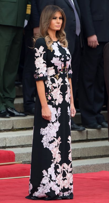 Melania Trump luce este vestido largo negro con bordados florales en blanco y tonos rosa suave en la ceremonia de bienvenida en el Gran Palacio del Pueblo en Beijing.