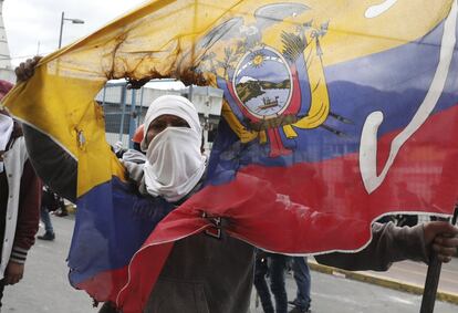 Un manifestante antigubernamental sostiene una bandera nacional dañada durante las marchas de protesta en Quito contra el presidente Lenin Moreno.