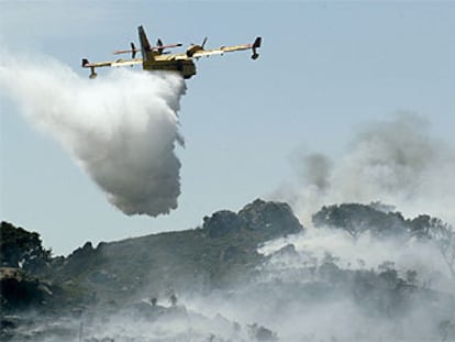 Un avión descarga líquido contra el fuego durante el incendio registrado ayer en Algeciras.