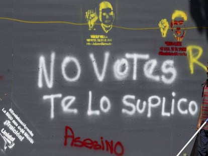 Un hombre pasa al lado de un cartel contra la votaci&oacute;n de este domingo.