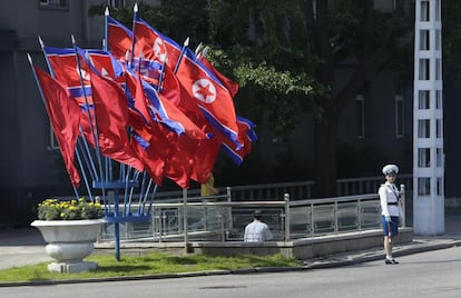 Una mujer policía frente a una decena de banderas norcoreanas, en una calle de la capital, Pyongyang.