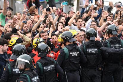 Um grupo de bombeiros se coloca entre os manifestantes e os policiais, em Girona.