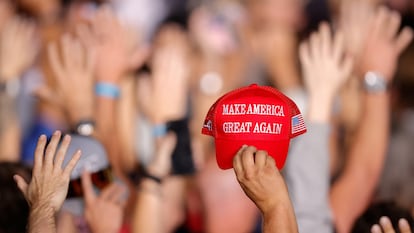 Seguidores de Donald Trump sostiene una gorra MAGA durante un mitin en Aurora, (Colorado).