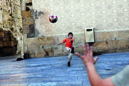 Los niños juegan al fútbol entre los muros romanos de la plaza del Fórum de Tarragona.