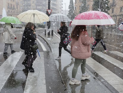 Varios peatones caminan en Salamanca bajo la nieve, este jueves.