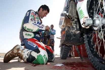 Marc Coma arregla su moto después del accidente, sin consecuencias, que sufrió en la etapa de ayer.