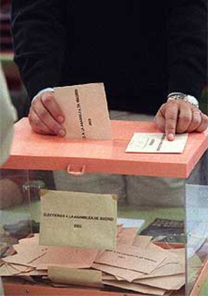 El presidente de una mesa electoral, mientras depositaba ayer un voto en la urna.