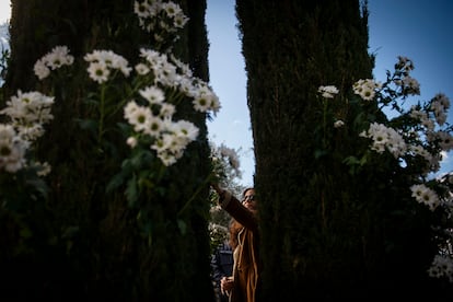 Una mujer coloca flores blancas durante el aniversario de los 20 años de los atentados terroristas en Madrid, este lunes en el parque de El Retiro.