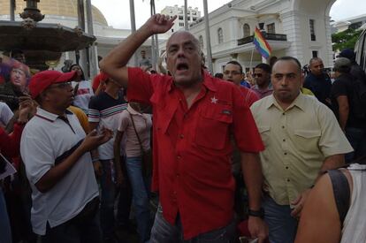 El alcalde de Caracas, Jorge Rodriguez (centro), grita consignas durante la protesta en la que los simpatizantes del Gobierno venezolano irrumpieron en la Asamblea Nacional para reventar la sesión en la que se discutiría un juicio político contra el presidente Nicolás Maduro.
