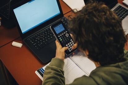 Un alumno usa una calculadora en clase. 