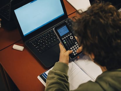 Un alumno usa una calculadora en clase. 