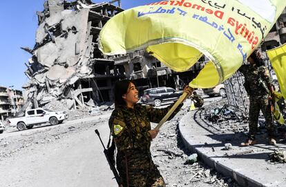 Rojda Felat, miembro de las Fuerzas Democráticas Sirias, ondea una bandera en la plaza Al-Naim para celebrar la liberación de Raqa, tomada por el Estado Islámico durante tres años, el 17 de octubre de 2017.