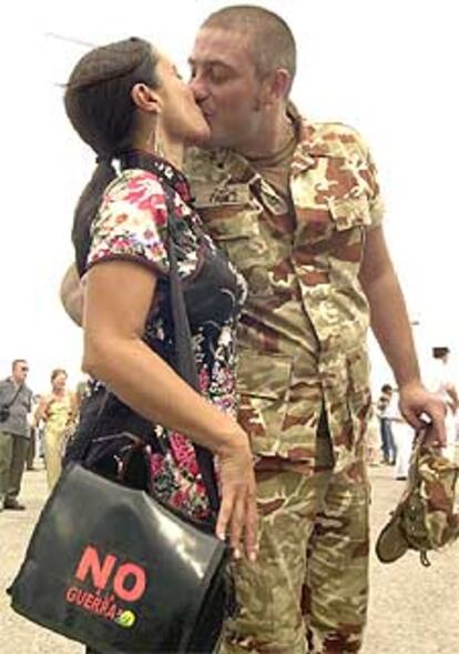 Un militar del buque <i>Galicia</i> besa a su pareja a su llegada a Rota.