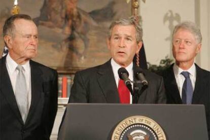 El presidente George W. Bush, flanqueado por los ex mandatarios George. Bush y Bill Clinton, anuncia una campaña para recaudar dinero para las víctimas del &#39;tsunami&#39;.