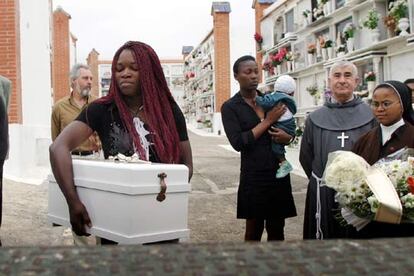 Una amiga de la madre de la víctima sostiene el ataúd de la pequeña Hope en el cementerio de Tarifa.