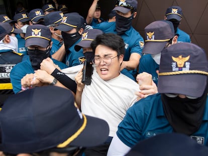 Agentes de policía detienen a uno de los manifestantes que han intentado entrar en la Embajada japonesa en Seúl en una protesta contra el vertido del agua contaminada de Fukushima.