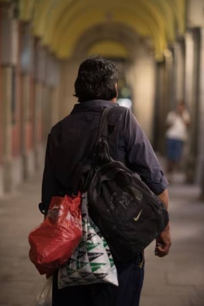 Raúl posa con sus pertenencias en los soportales de la plaza Mayor.