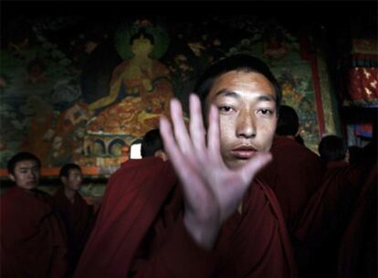 Un monje tibetano rechaza ser fotografiado por un periodista durante la visita al templo de Jokhang.