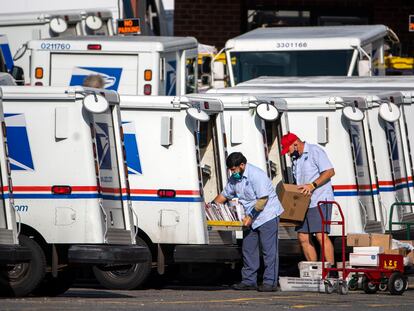 Trabajadores del servicio postal de EE UU se preparan para repartir el correo.