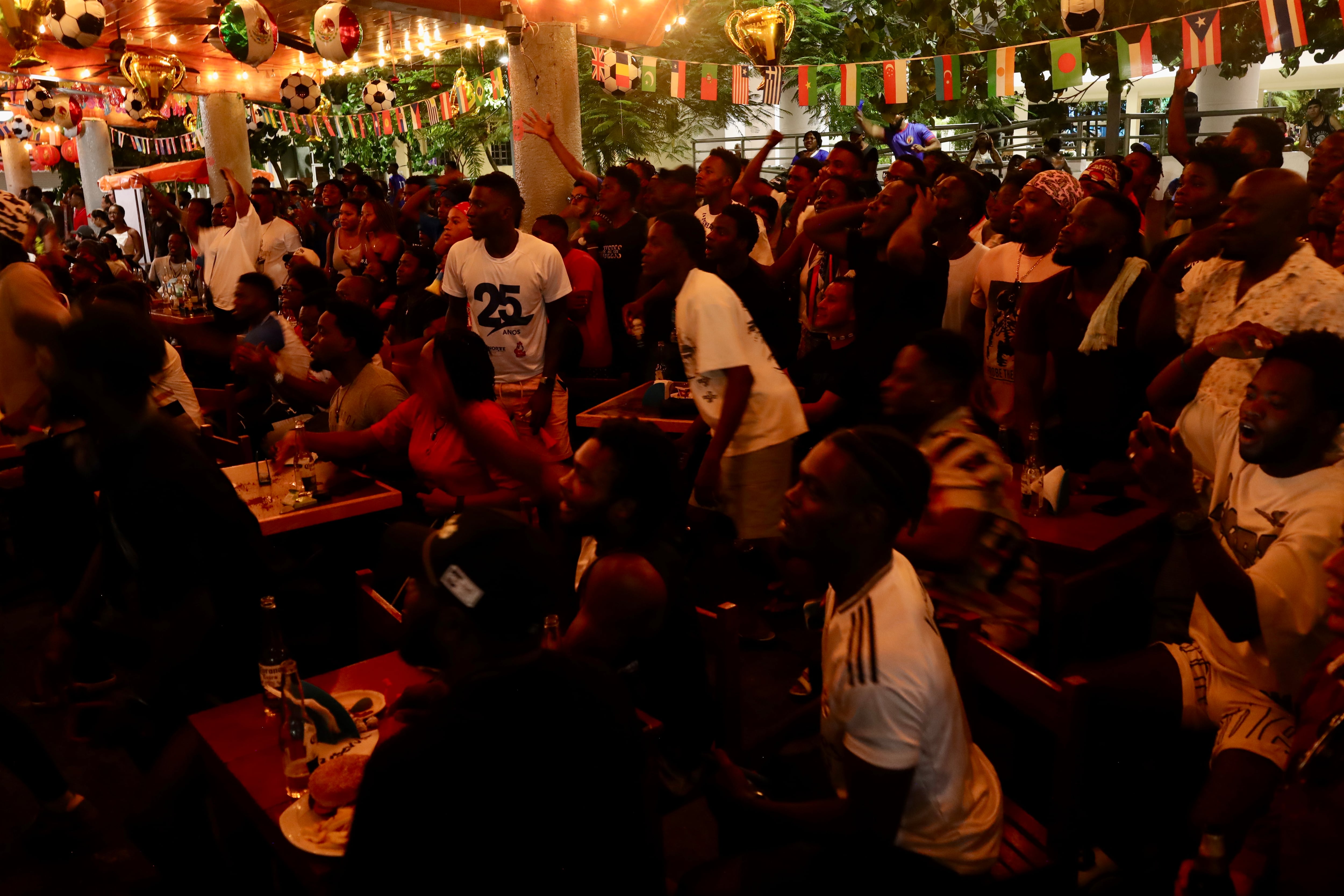 Hatianos observan el partido de fútbol de su selección ante Escocia, en un restauranteen Tapachula, el 13 de junio.