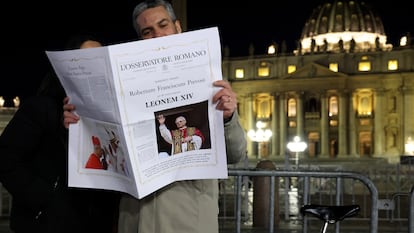 Dos personas leen la edición especial del periódico vaticano 'L'Osservatore Romano' sobre la elección del cardenal Robert Prevost como Papa León XIV, el 08 de mayo de 2025 en Ciudad del Vaticano, Vaticano.