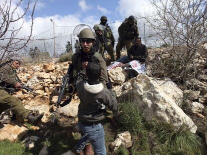 Un soldado israel&iacute; empuja a un ni&ntilde;o palestino durante los enfrentamientos en Beit Omar, cerca de Hebr&oacute;n, en Cisjordania, el d&iacute;a 17 de marzo de 2012.