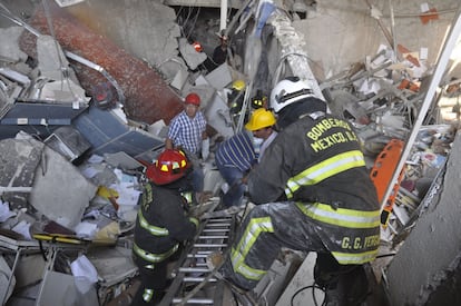 Los bomberos trabajan entre los escombros que ha dejado una explosión en el edificio de Pemex en la Ciudad de México.
