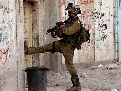 Un soldado israelí se dispone a entrar por la fuerza en una casa en Qabatiye, al sur de Yenín (Cisjordania).