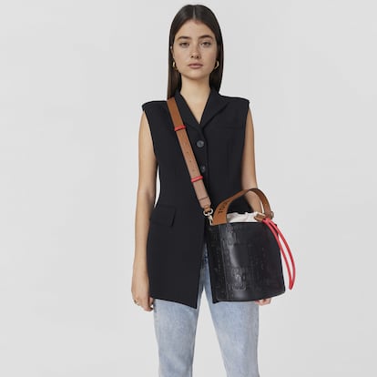 TOUS propone una fusión perfecta entre el bolso bucket más tradicional y una versión más contemporánea. Lo consigue gracias a su piel grabada con el logo y a su original combinación de colores negro, marrón y rojo. (159 euros).