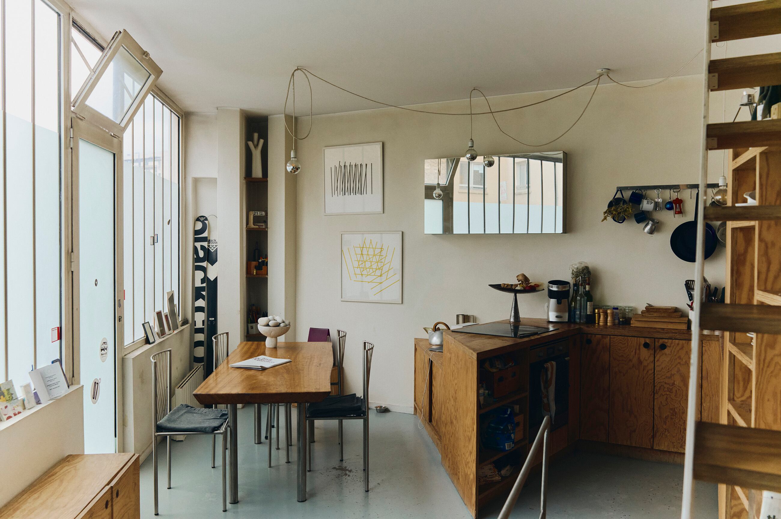 La cocina de la casa está hecha con madera laminada. Al fondo, obras de François Morellet y esquíes Black Crows, cuya imagen diseñó Tloupas.