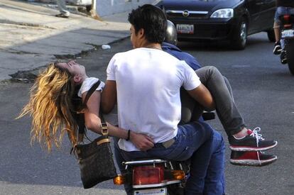 Genesis Carmona &eacute; levada em uma moto depois de ser atingida por um tiro.