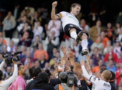 Los jugadores del Valencia mantean a Baraja, ayer en Mestalla.
