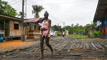 Una mujer camina con su bebé en brazos por una calle de Isla Mono, en el departamento colombiano de Chocó, el 23 de abril de 2019.