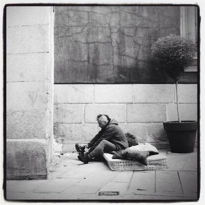 23-10-2014. Un hombre se levanta del lugar donde ha pasado la noche en las inmediaciones de la calle Mayor.